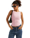 Woman in pink sleeveless ribbed tank top, high-waisted jeans, sunglasses, and black shoulder bag