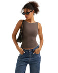 Woman in brown sleeveless crop top and high-waisted jeans, stylish casual outfit