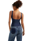 Navy blue women's tank top with open back, paired with denim jeans, showcasing stylish activewear