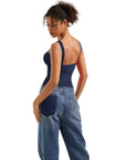 Woman in navy blue backless tank top and wide-leg jeans, showcasing stylish women's clothing