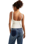 Cream backless tank top with wide straps paired with blue jeans, women's fashion